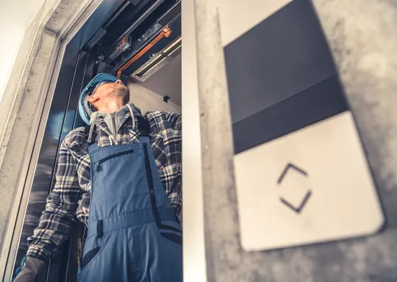 Technicien Tracklift effectuant la maintenance d’un ascenseur pour les syndicats de copropriétés 
