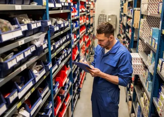 Technicien effectuant l’inventaire de pièces d’ascenseur reconditionnées dans un entrepôt